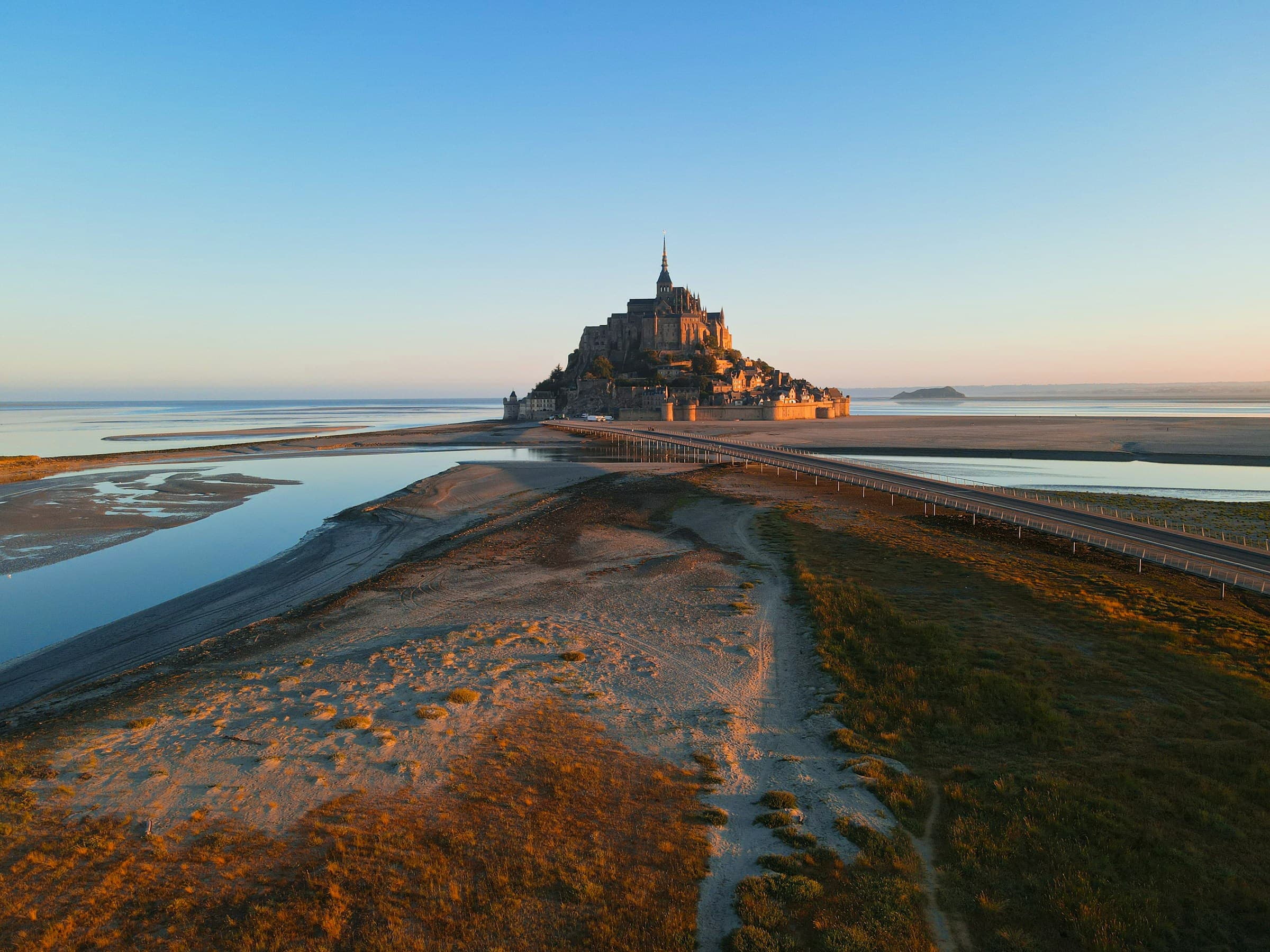Le Mont-Saint-Michel au lever du soleil, vu depuis la baie